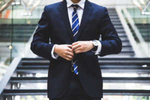 Man flossing in his suit because he just landed a new business partnership.